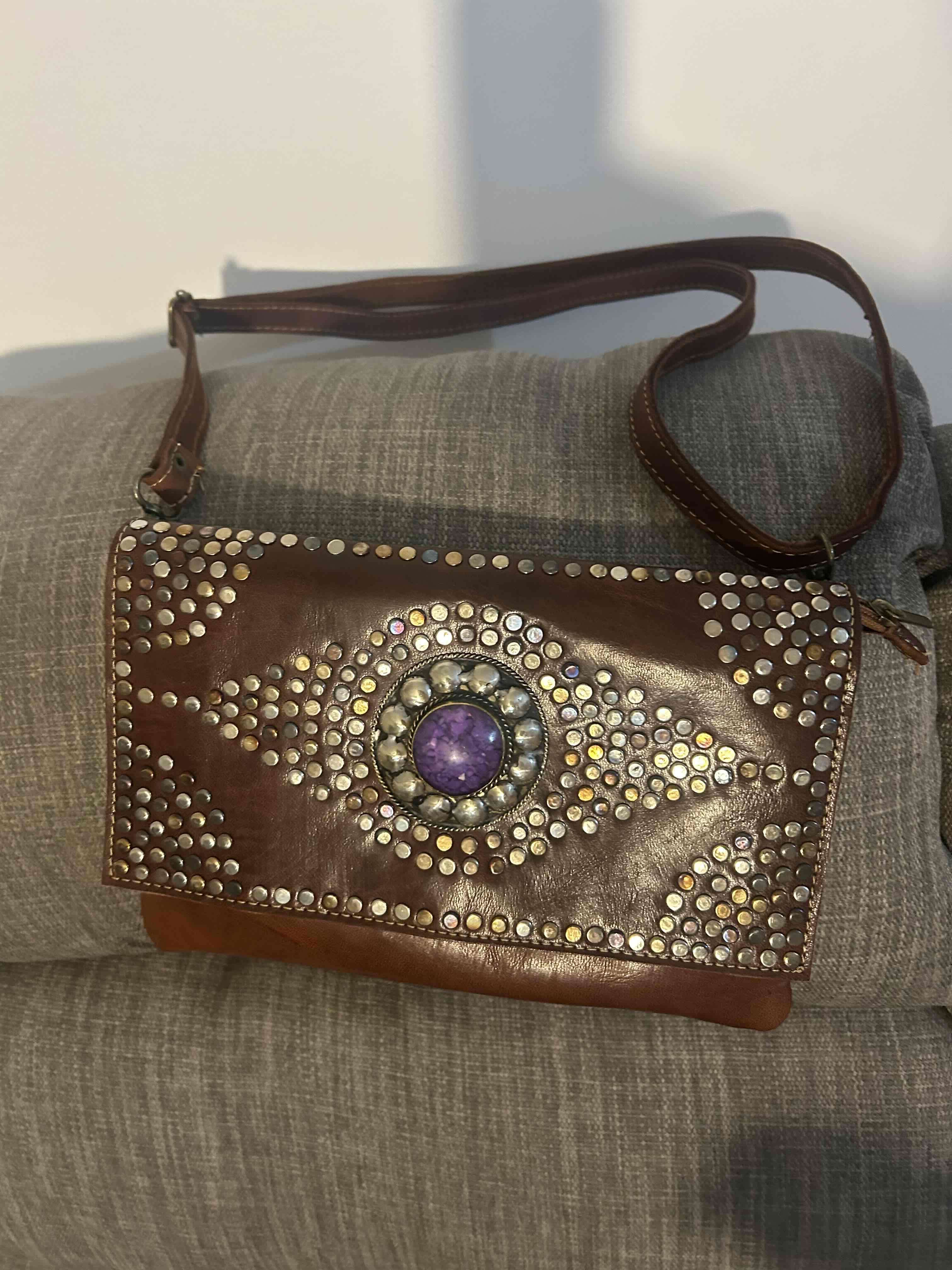 Cartera marrón con adornos metálicos