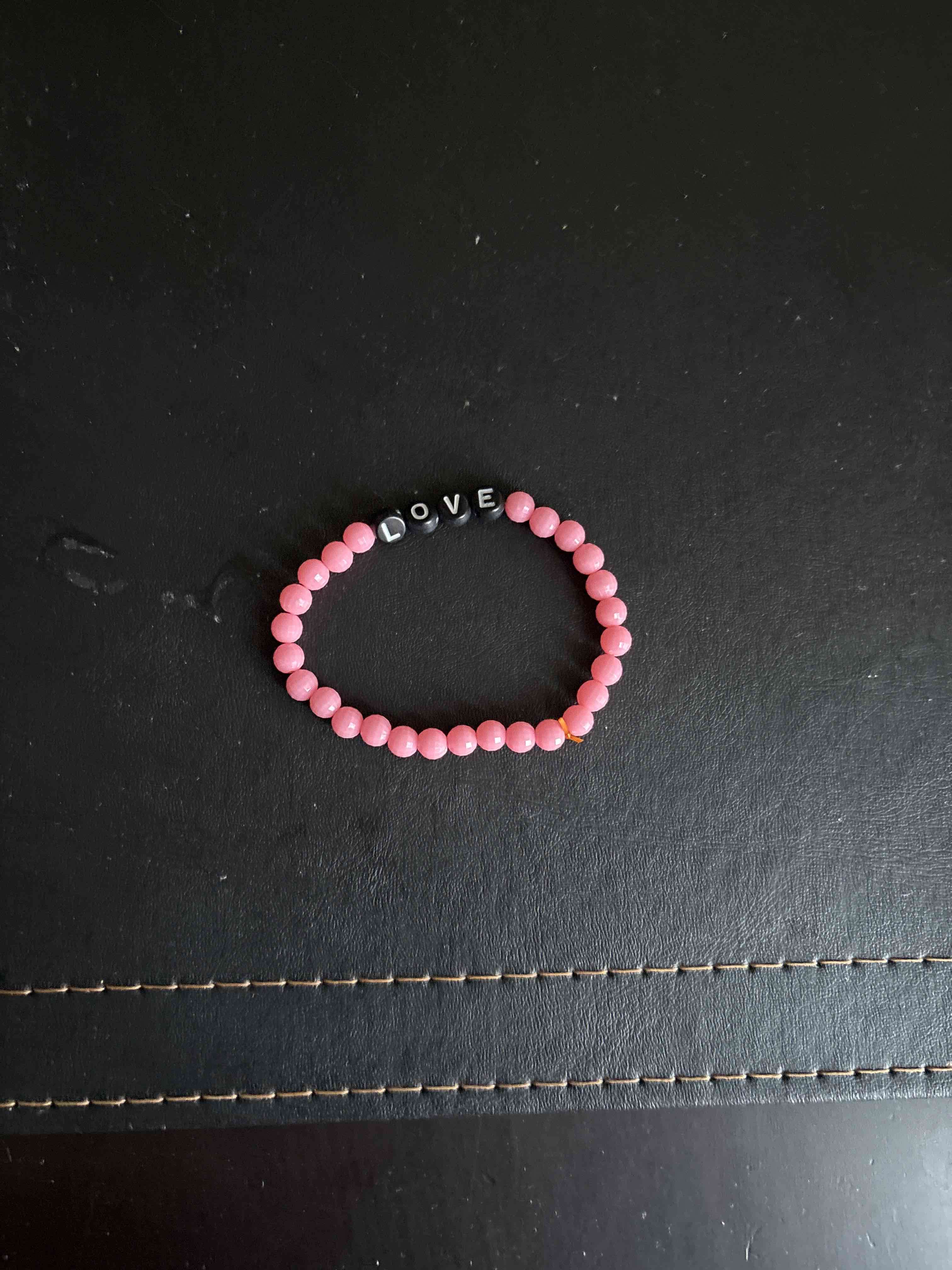 Pulsera rosada con letras