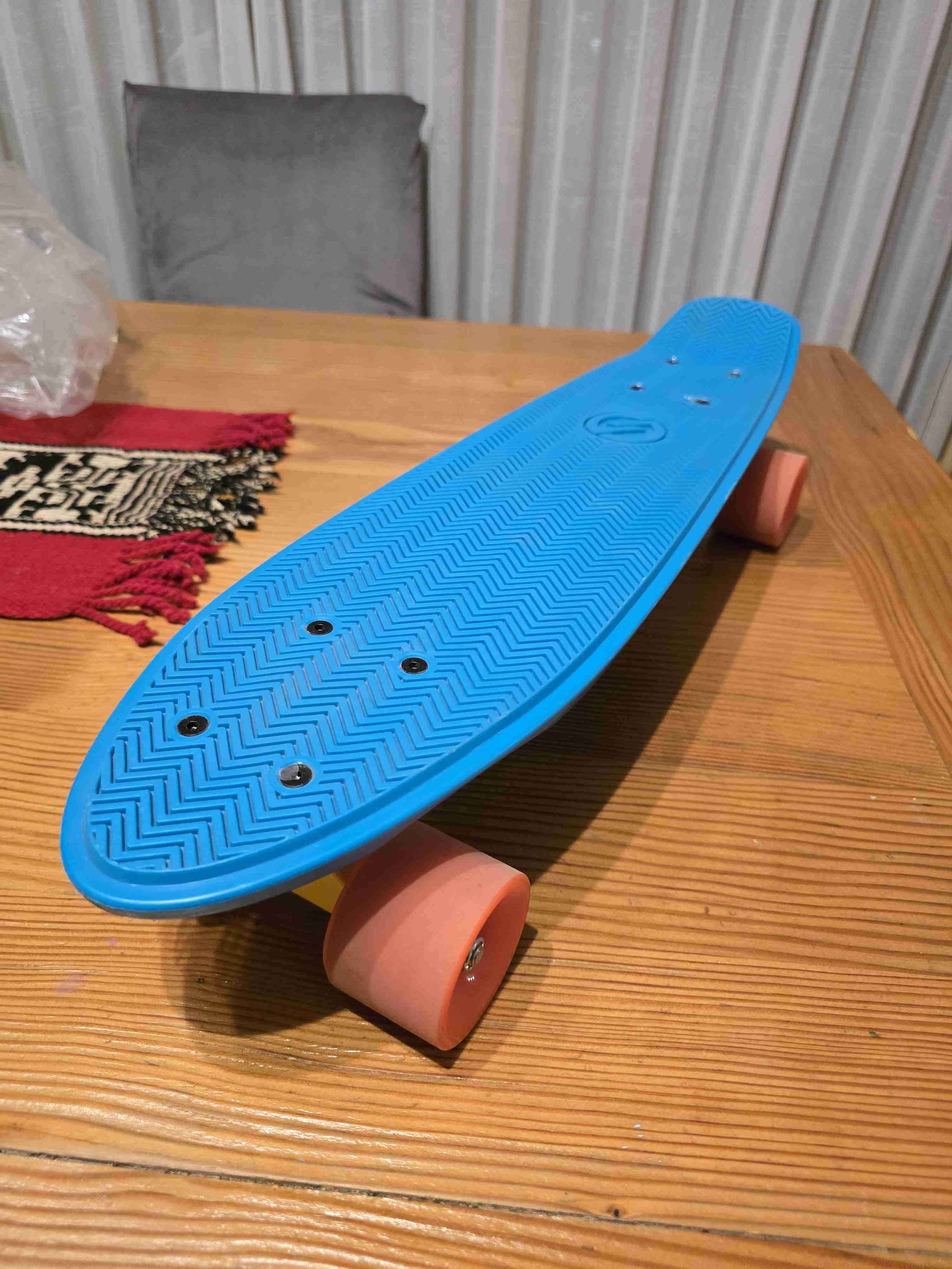 Skateboard azul con ruedas naranjas