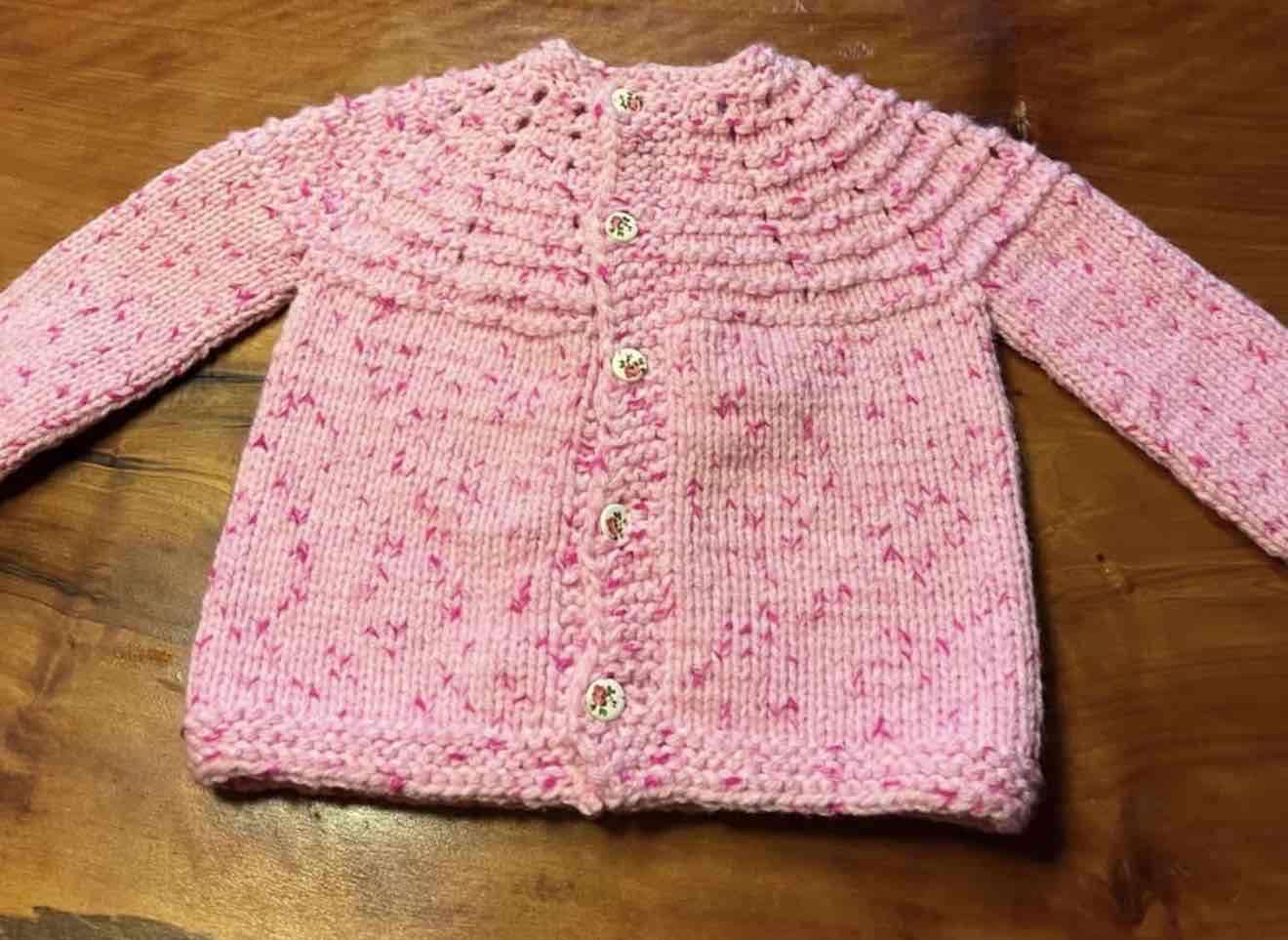 Cardigan de niña rosa tejido a mano
