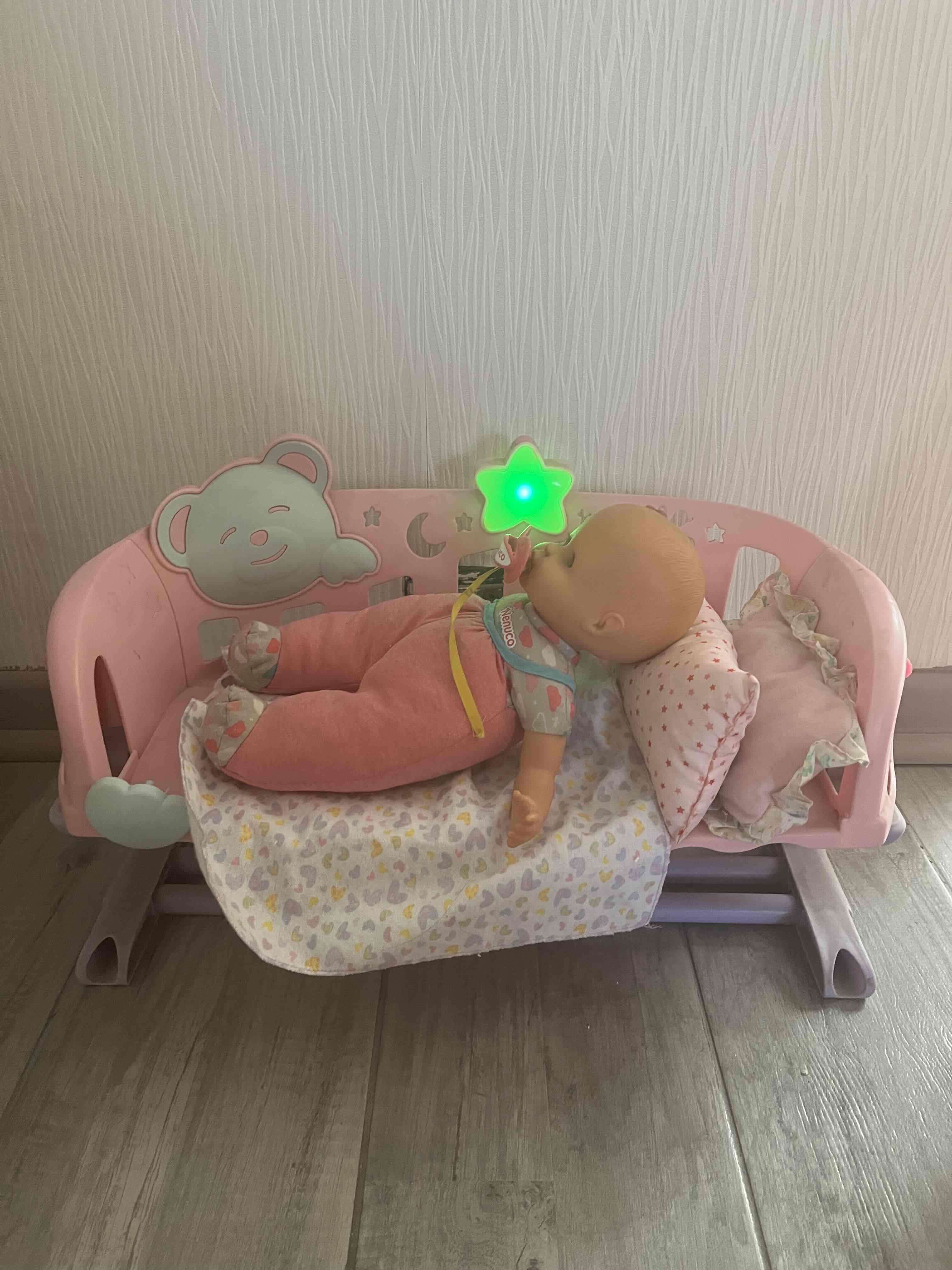 Cuna de juguete con muñeca