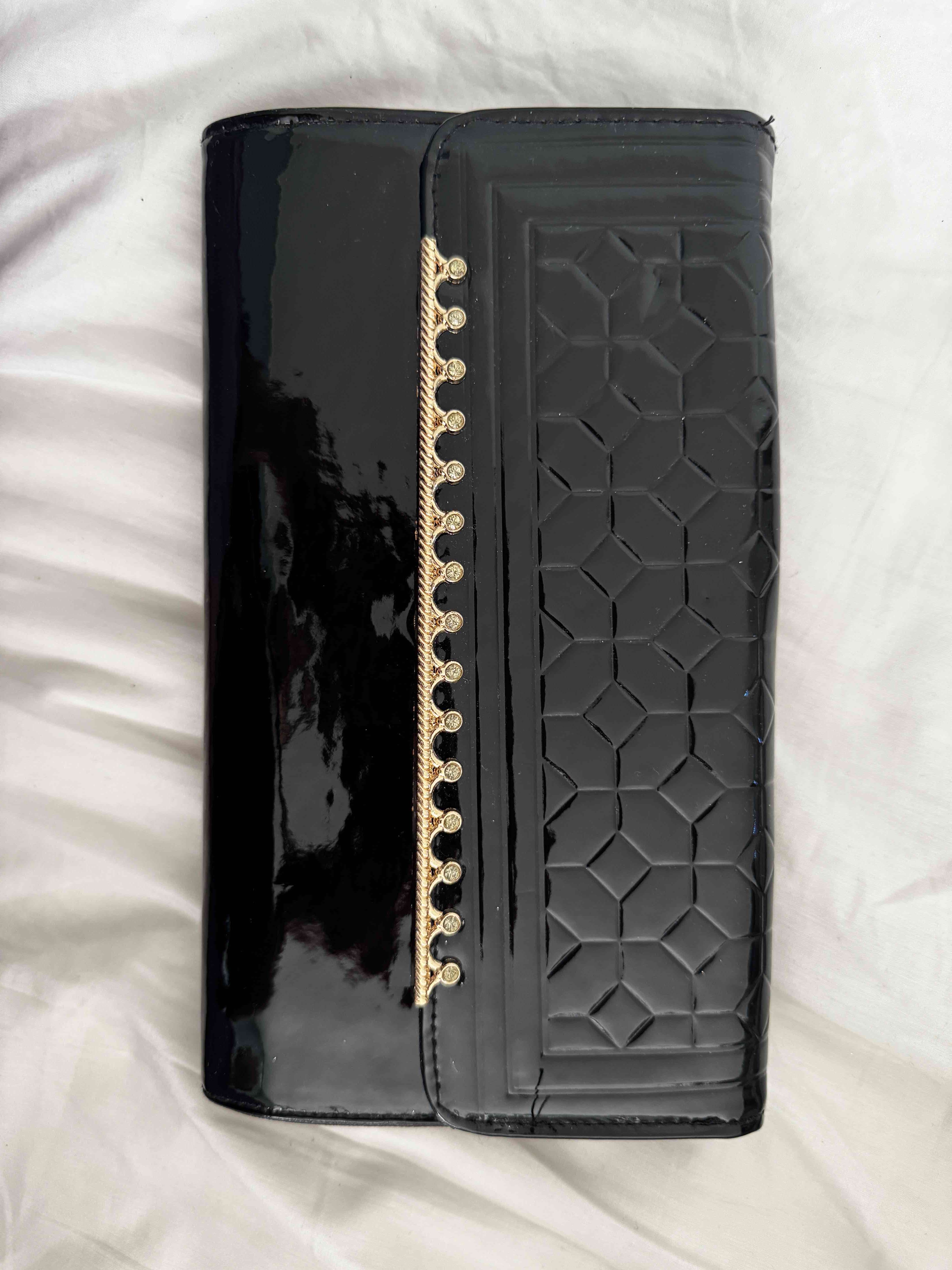 Cartera negra con detalles dorados