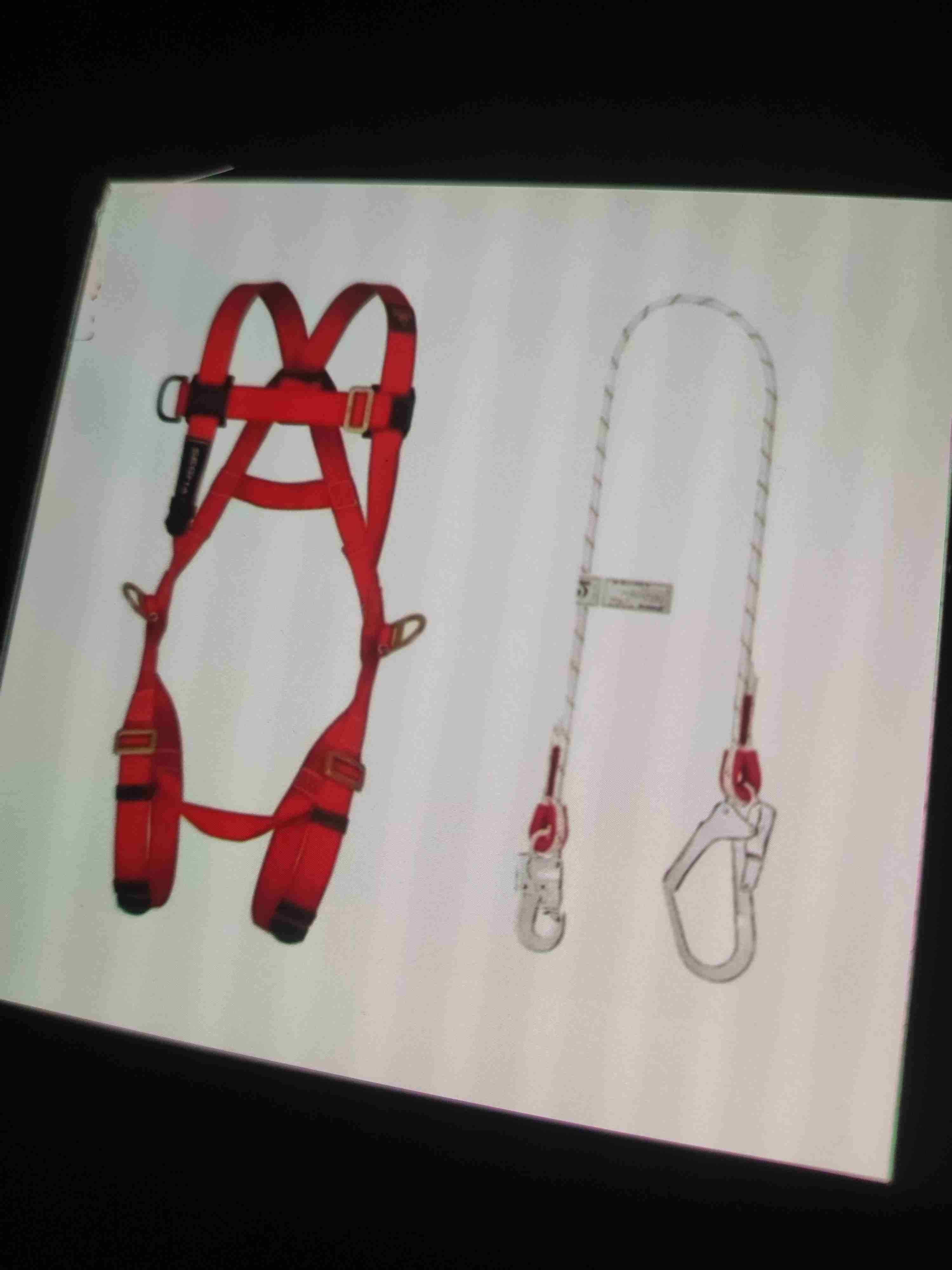 Arnés de seguridad rojo y guantes para soldar