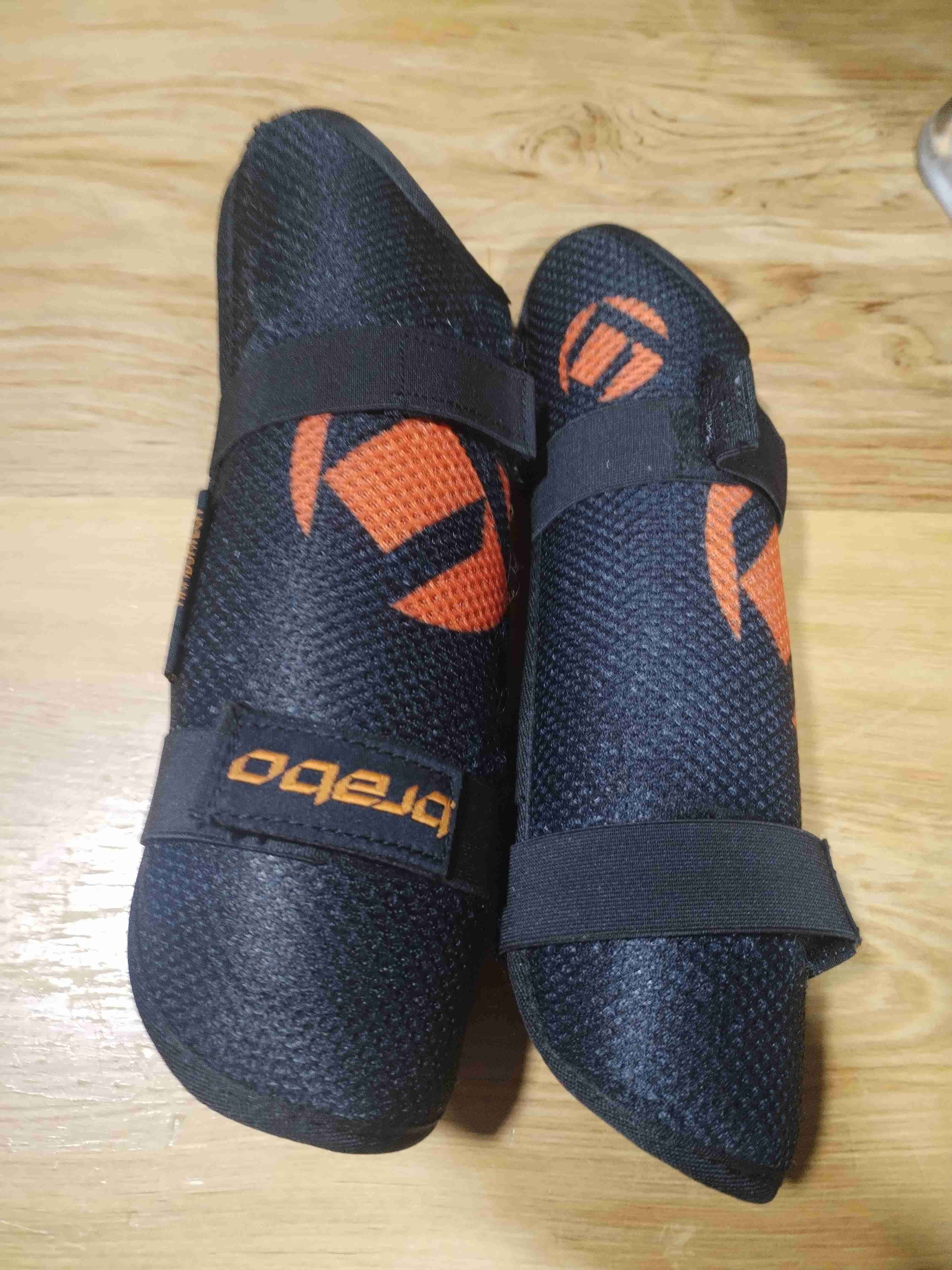 Canilleras deportivas negras y naranjas