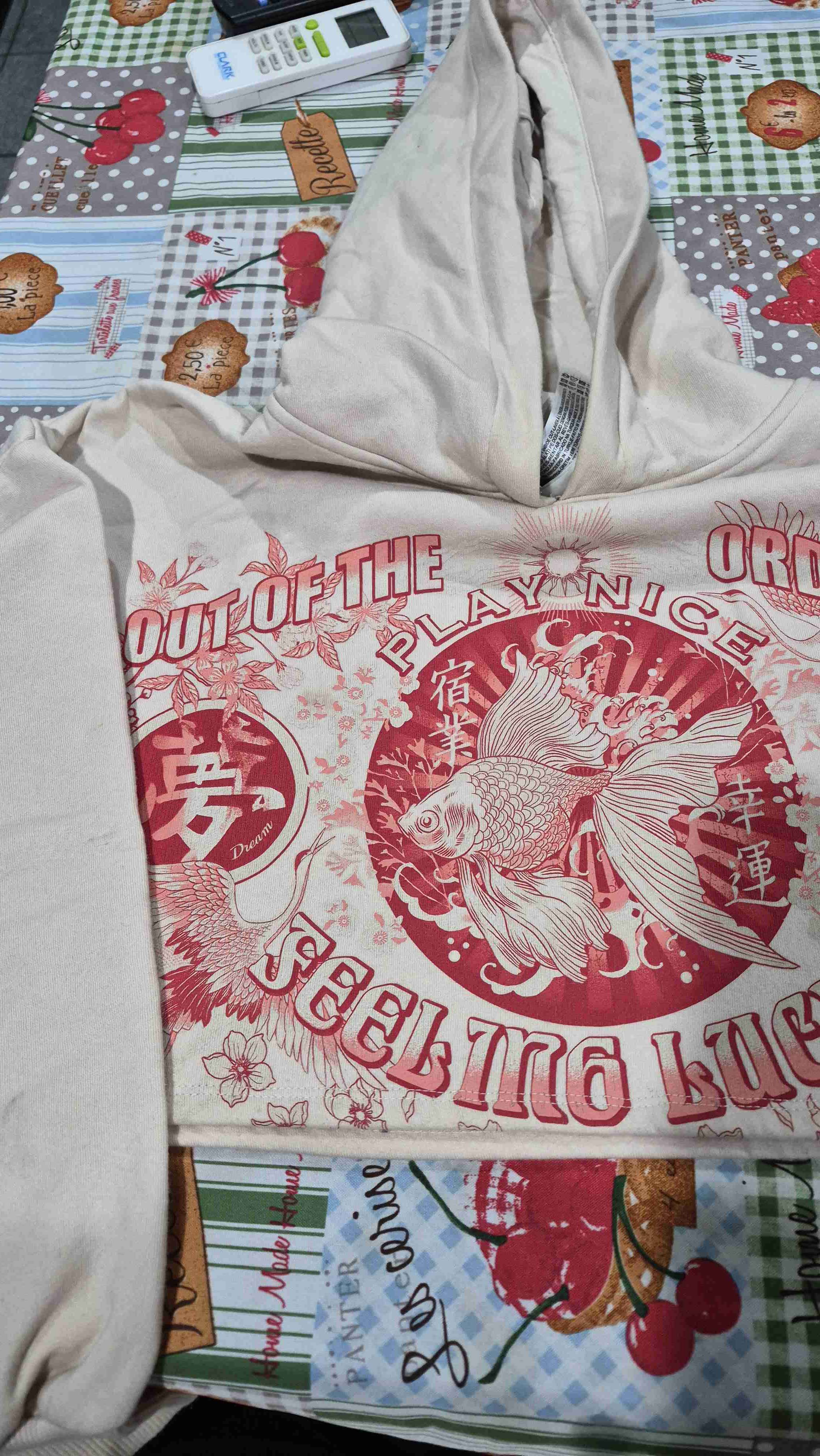 Polerón beige con estampado rojo