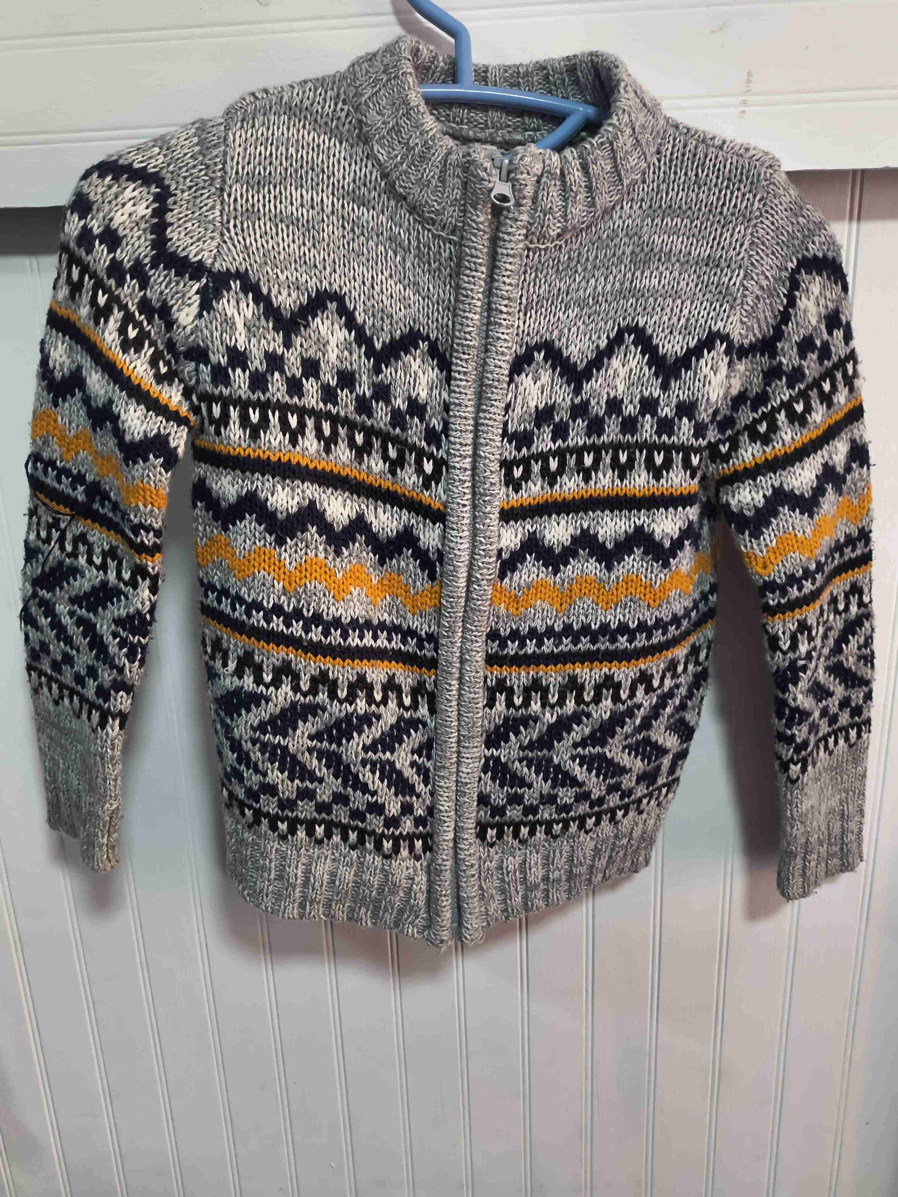 Chaleca tejida gris con detalle azul y anaranjado