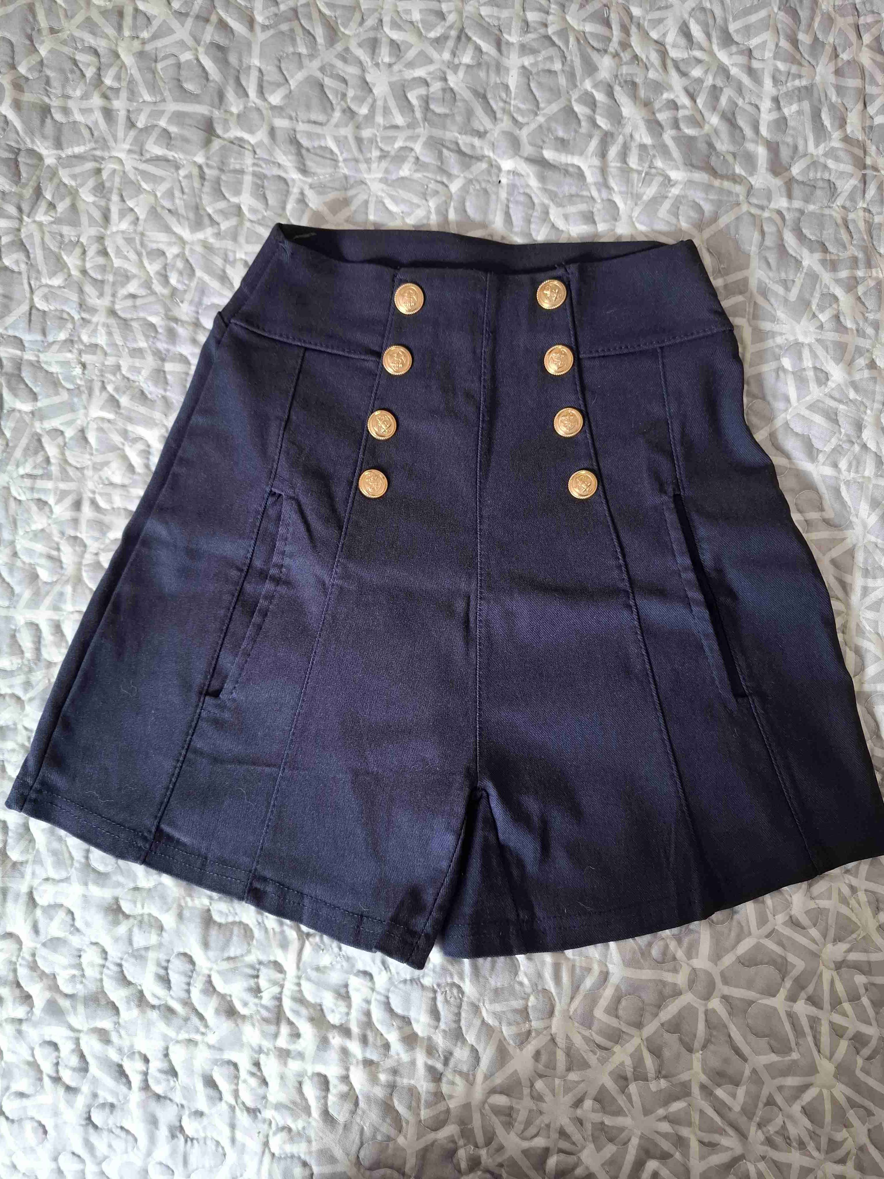 Shorts oscuros con botones dorados