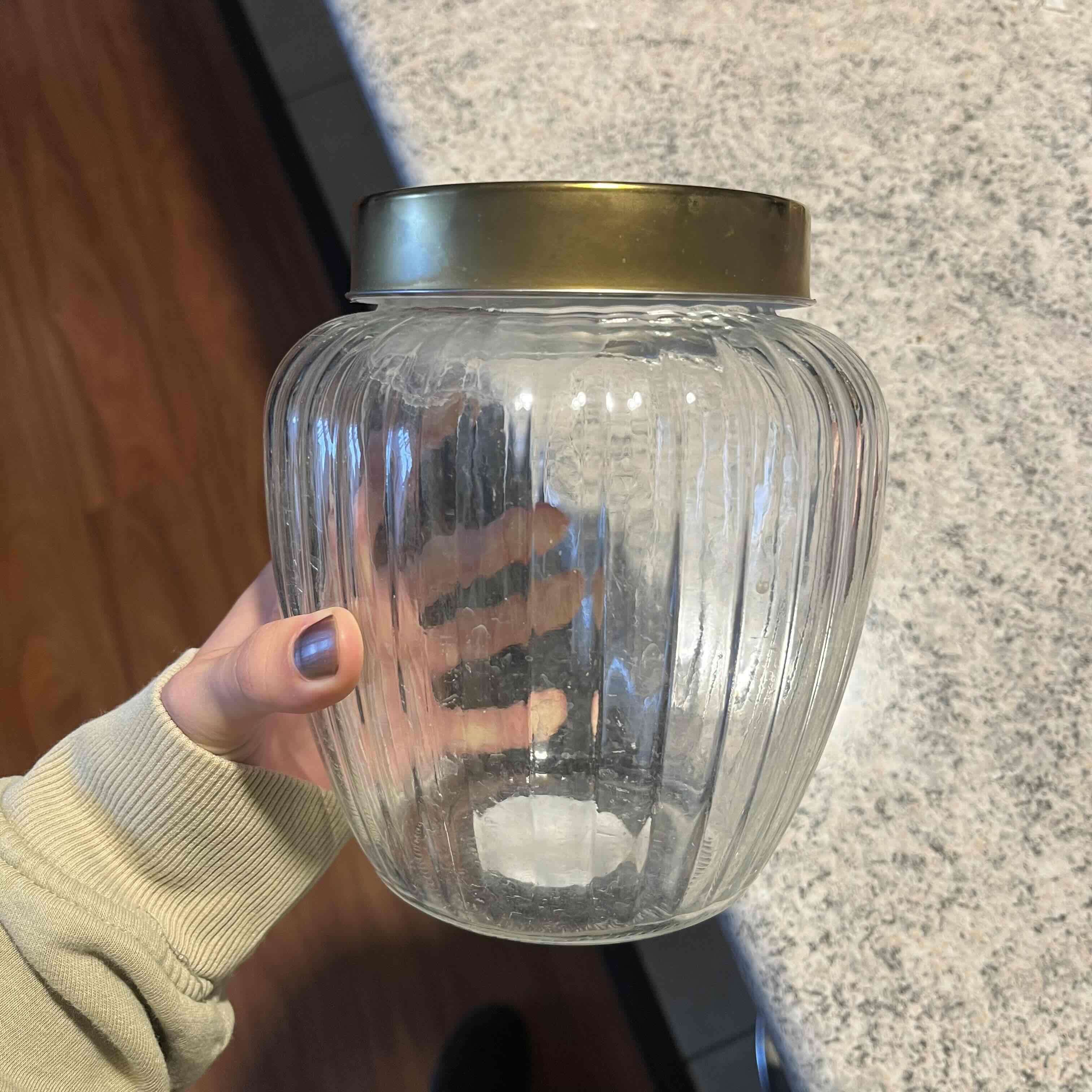 Frasco de vidrio con tapa dorada