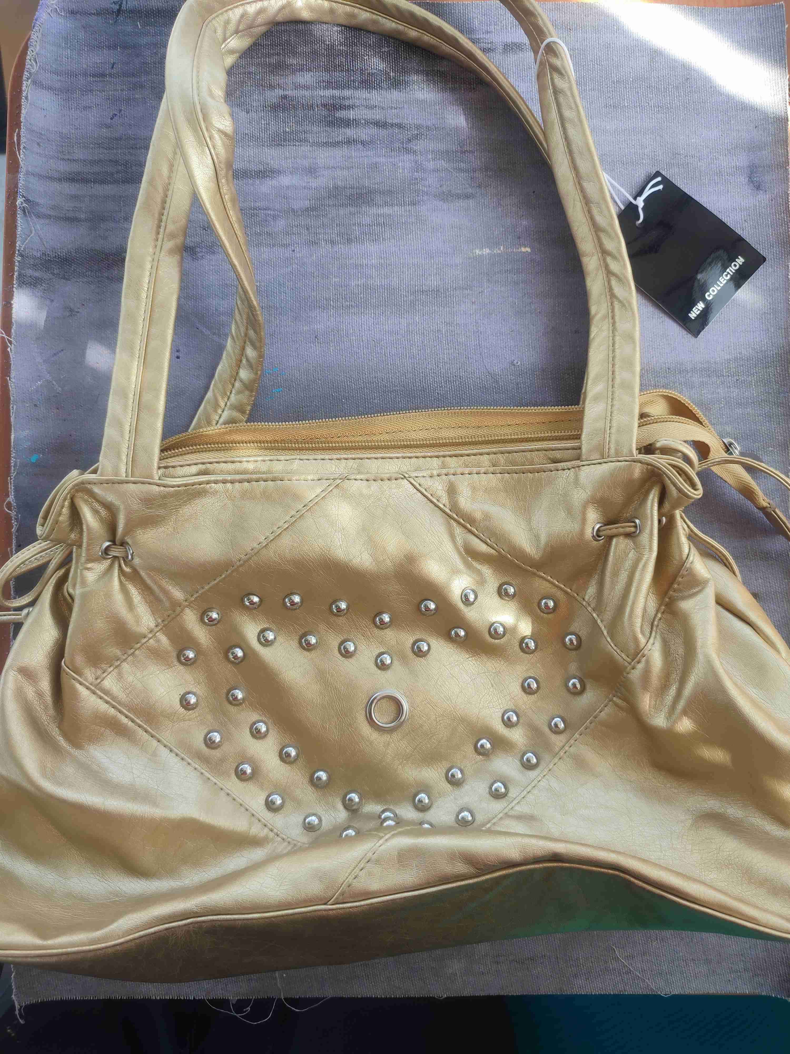 Cartera dorada con tachas