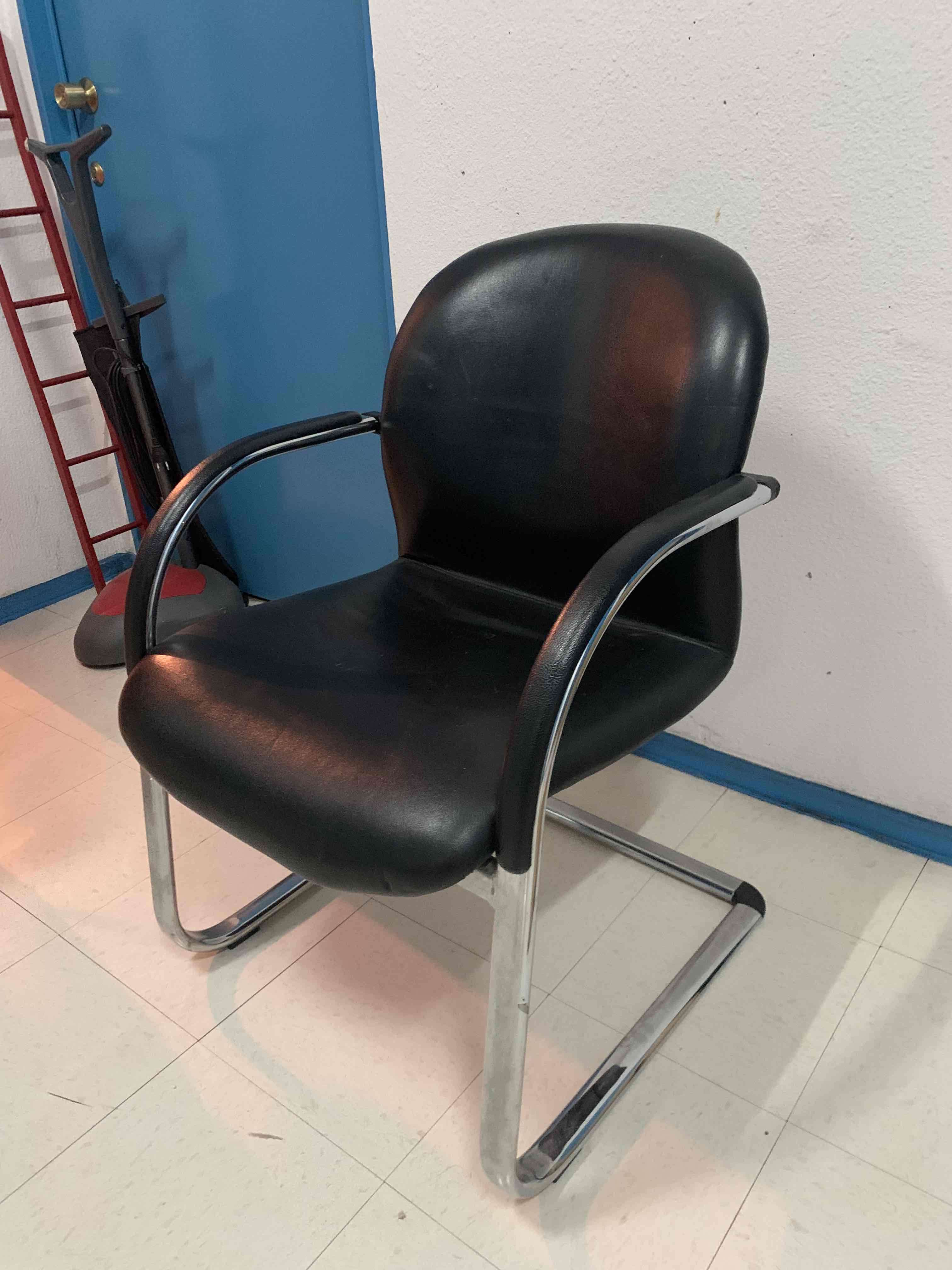 Silla de cuero negra con estructura metálica