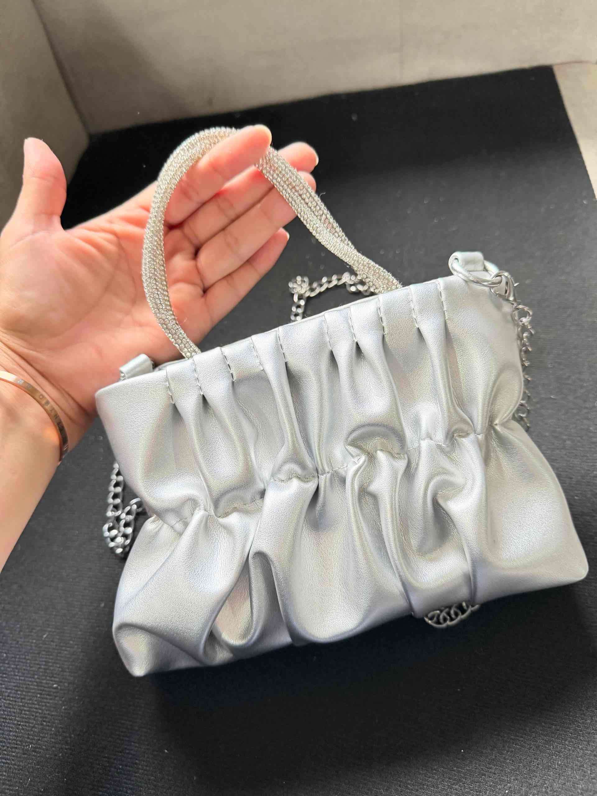 Cartera plateada con asa metálica