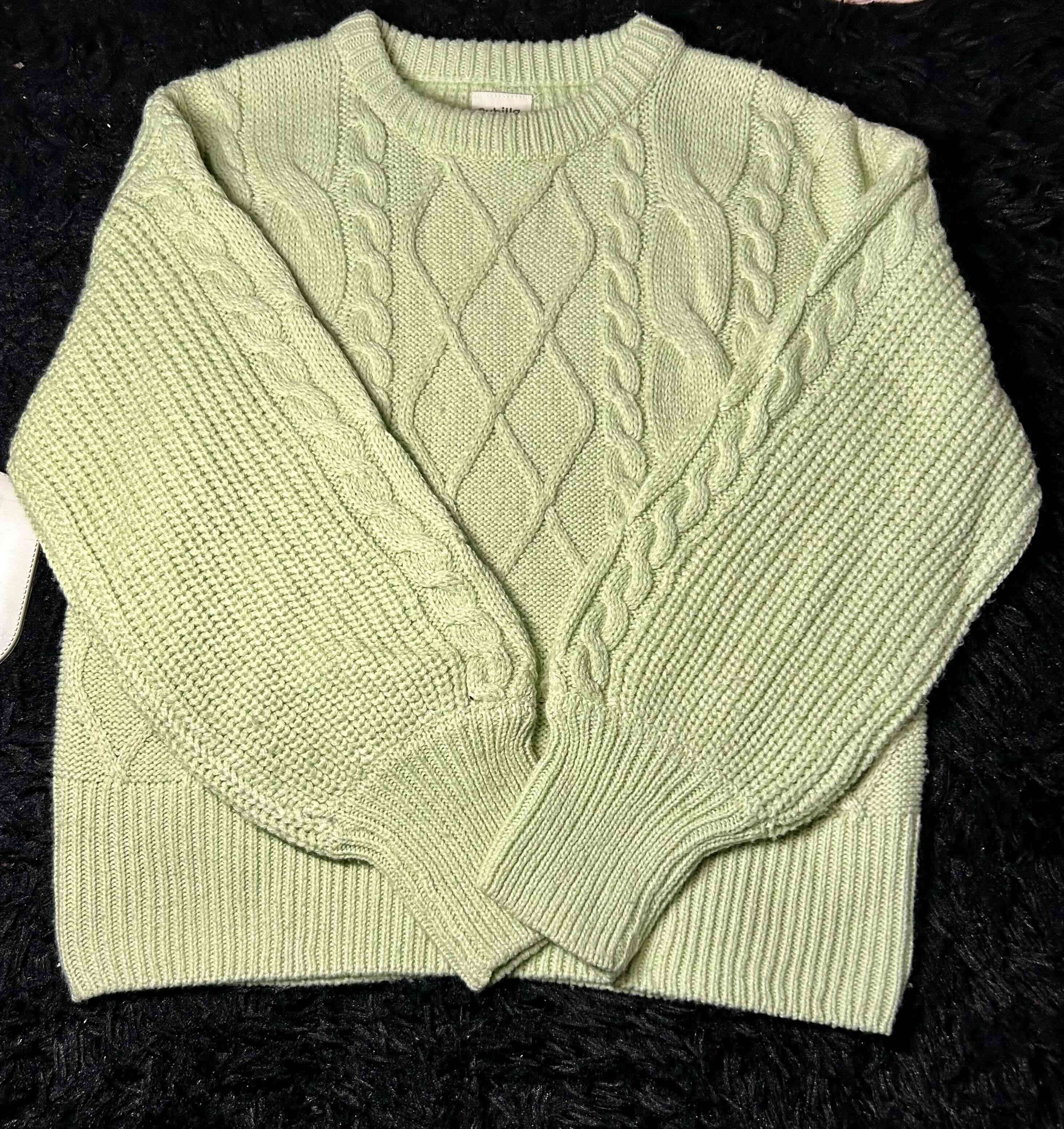 Suéter verde de lana trenzada