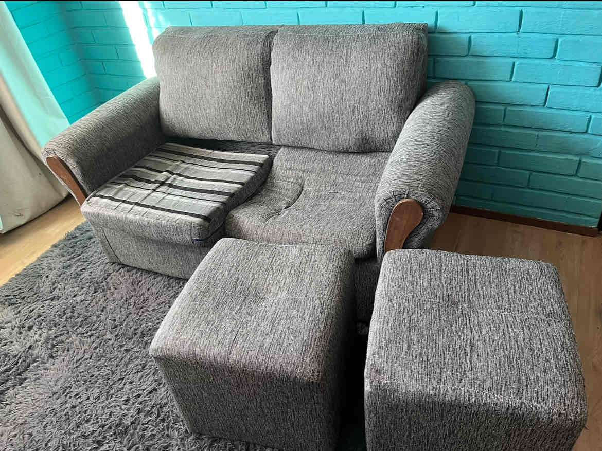 Sofá seccional gris con pufs