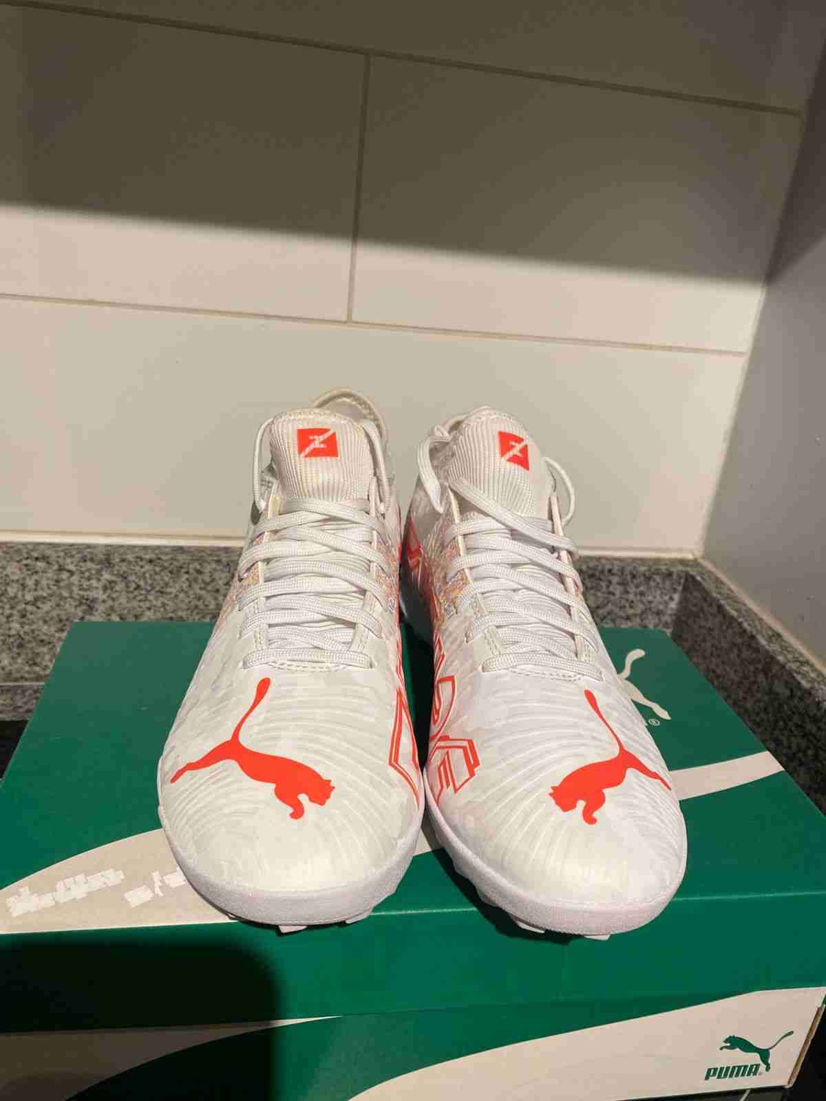 Zapatos de fútbol Puma blancos y naranjas