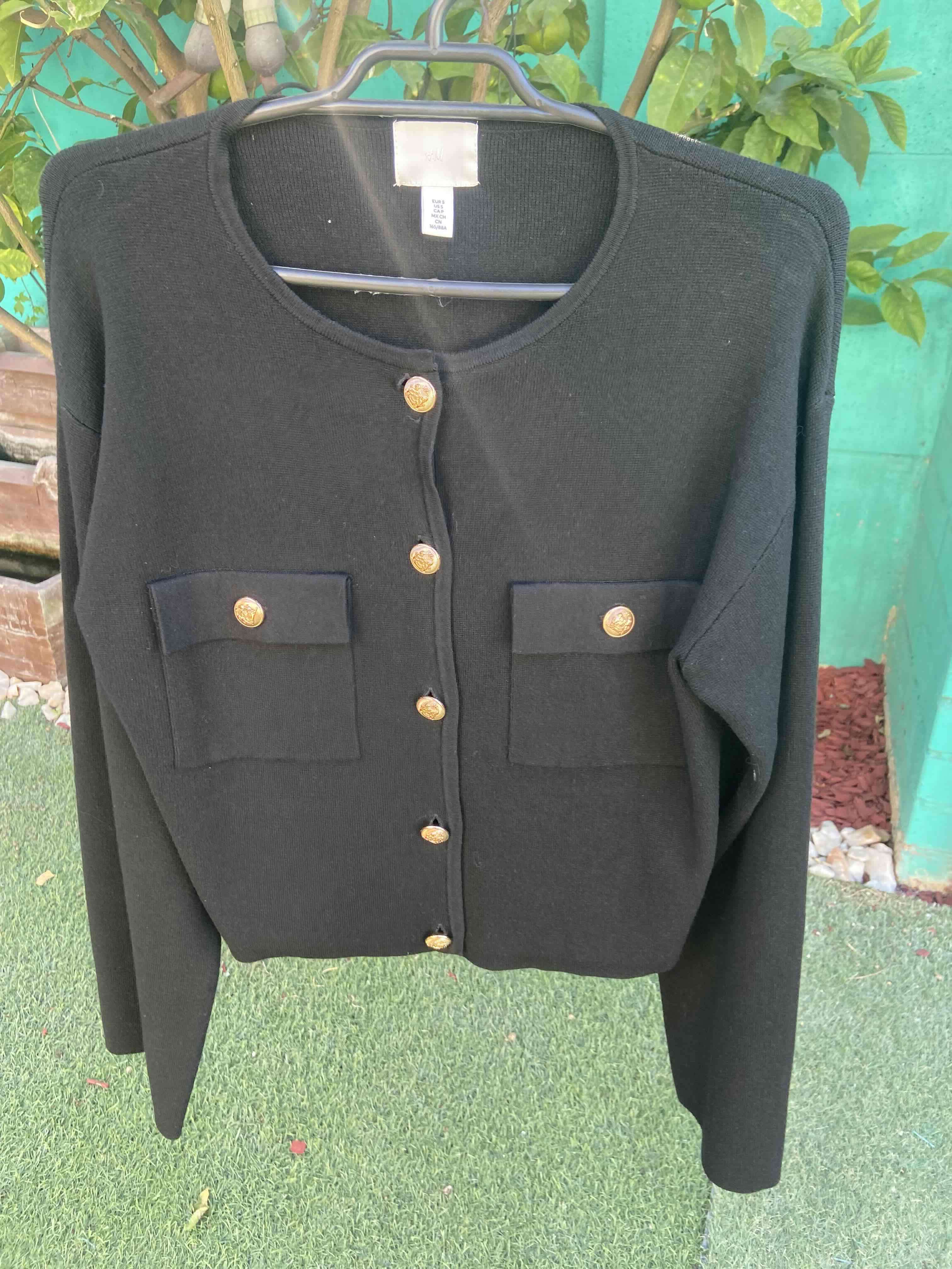 Chaleco negro con botones dorados