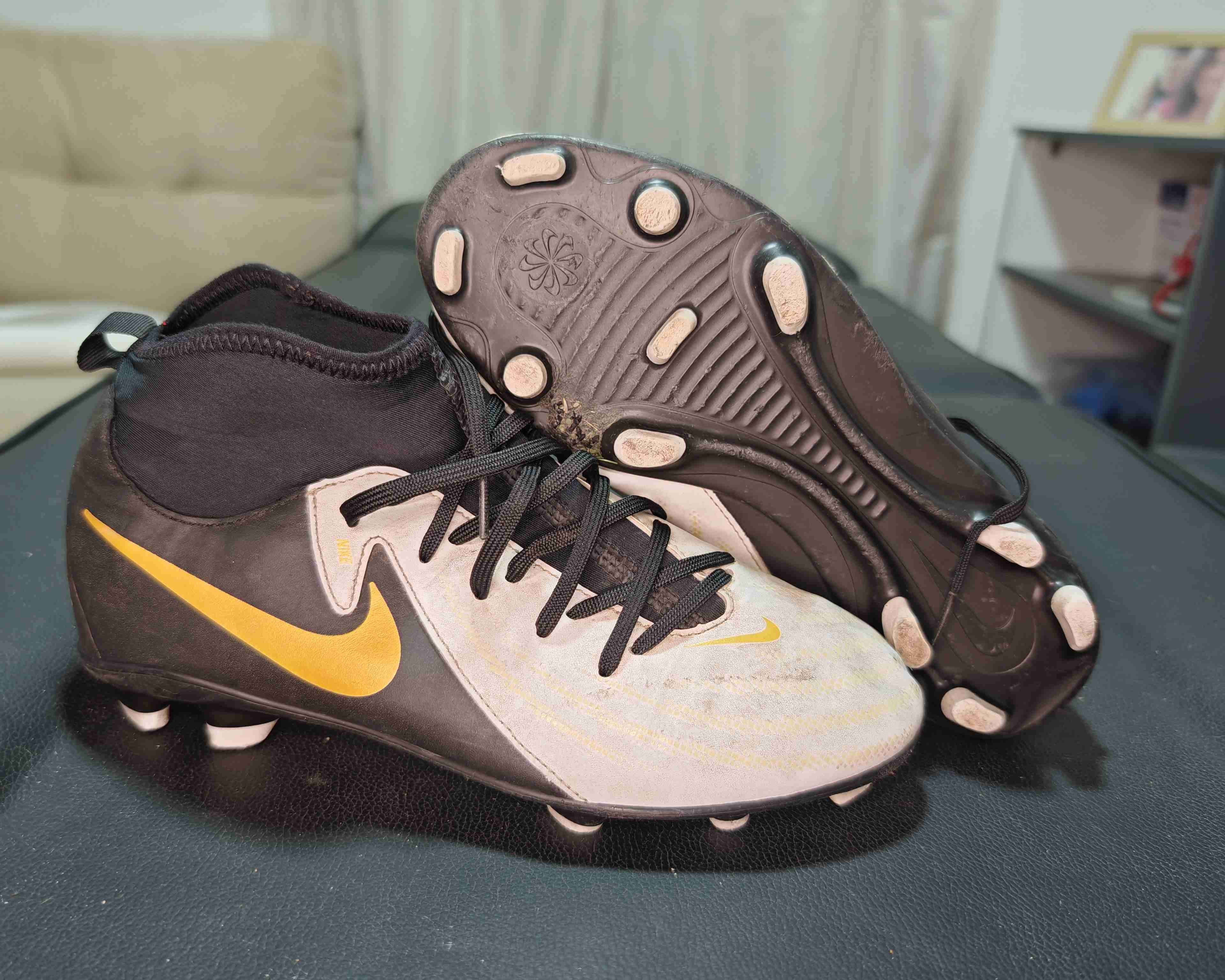 Botines de fútbol negros con logo dorado