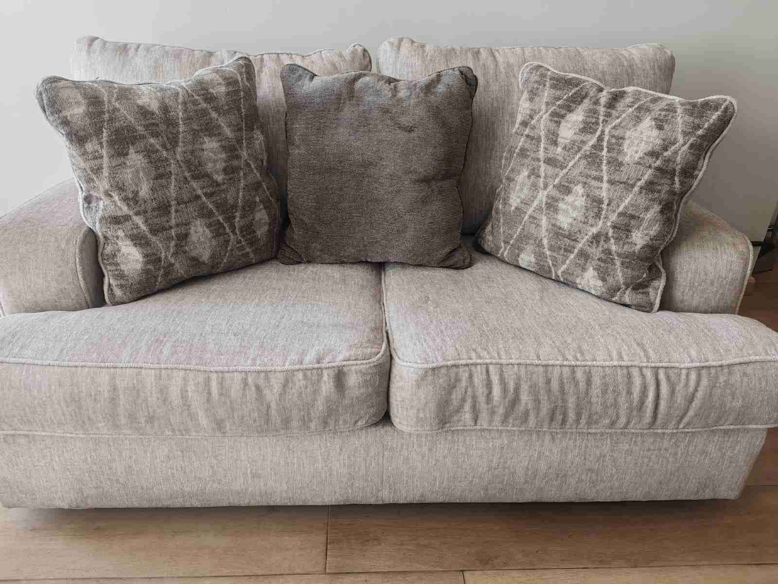 Sofá beige con cojines decorativos