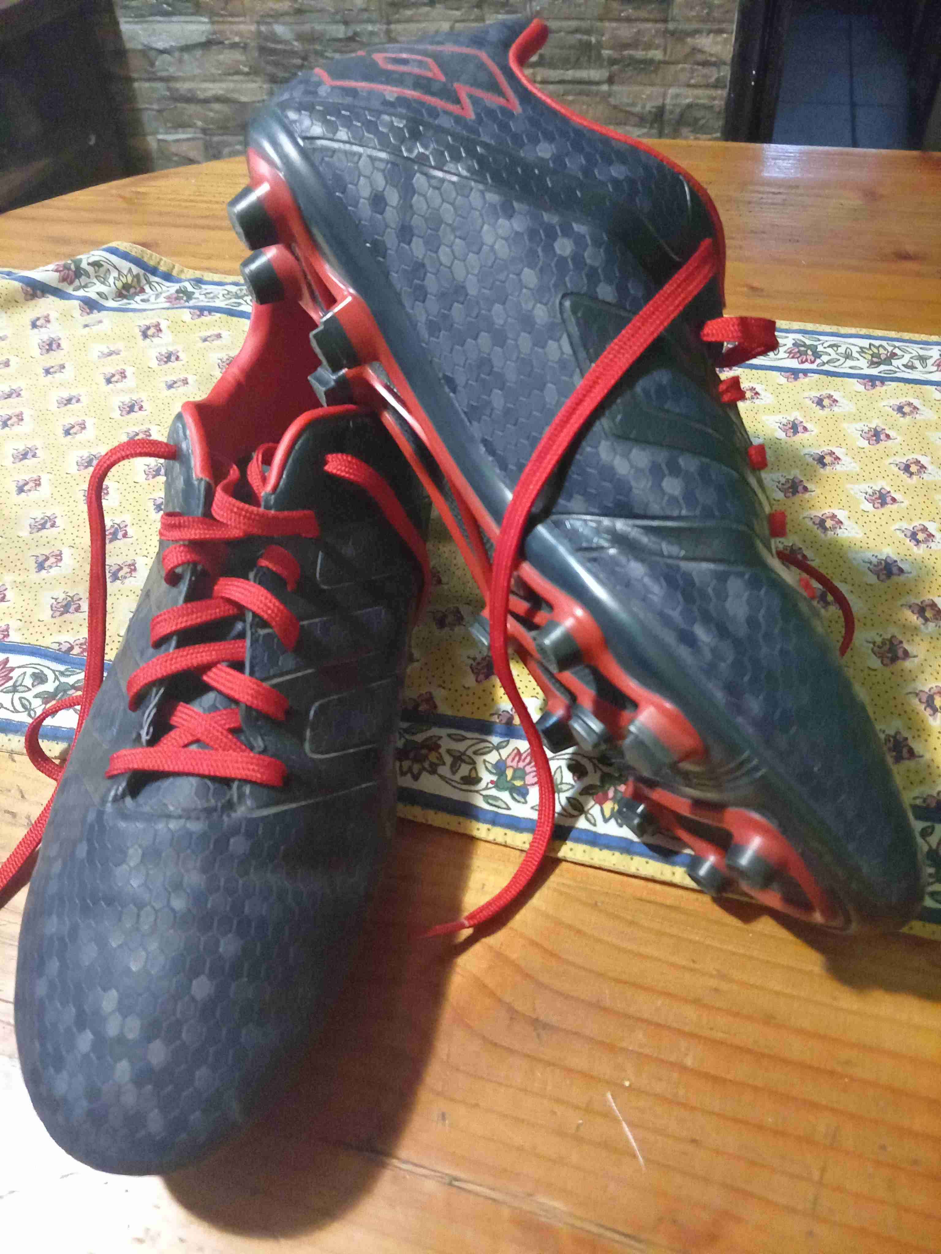 Botines de fútbol negros y rojos marca Lotto