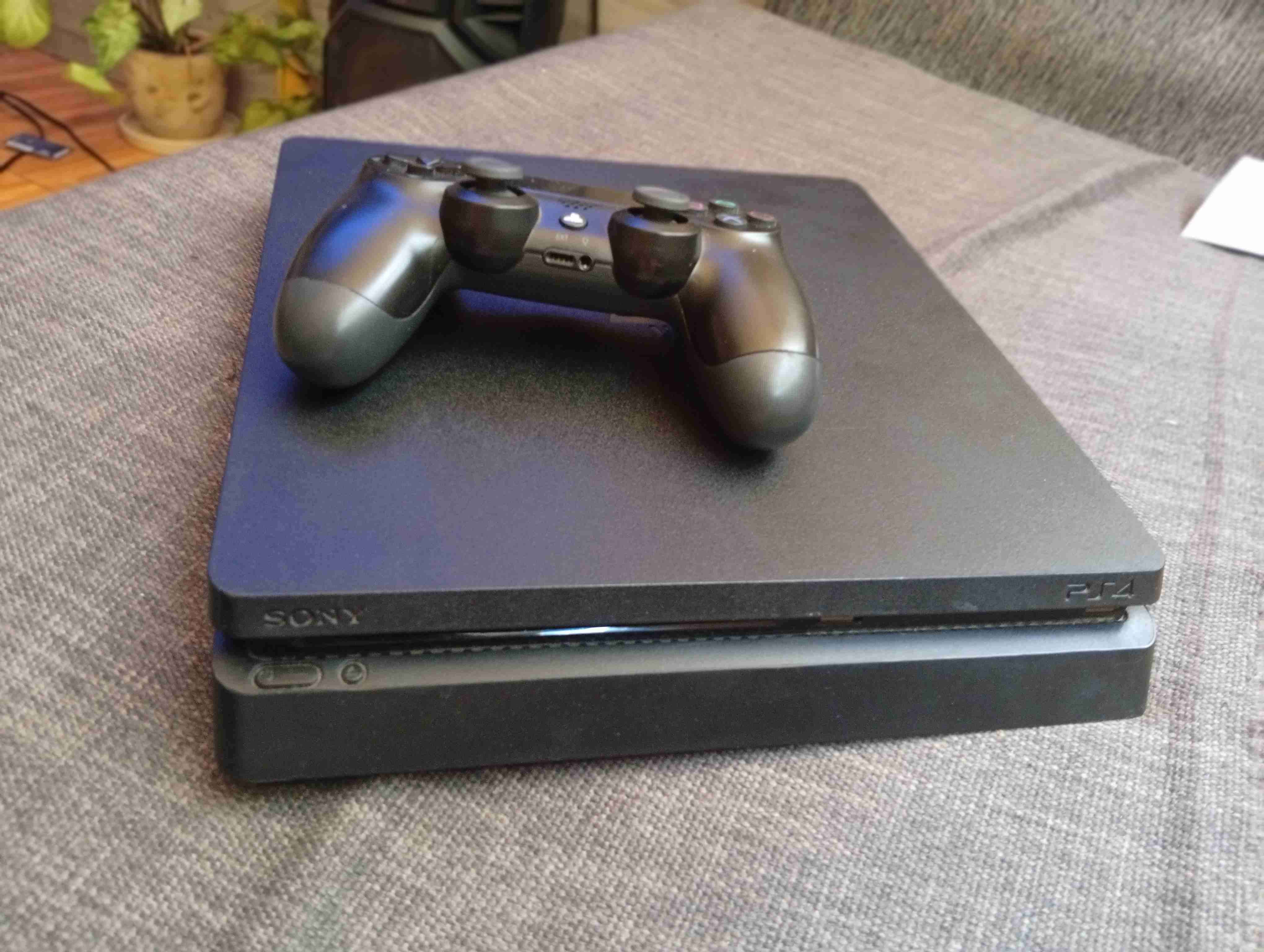 Consola PS4 con control y los juegos que se ven - miniatura 1