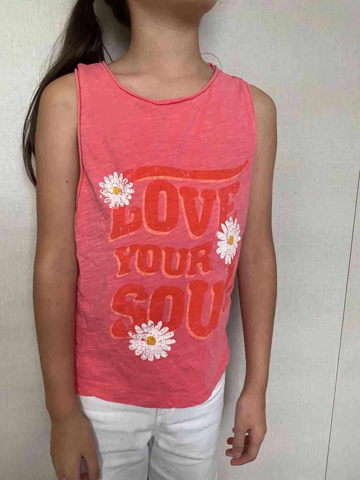 Polera sin mangas rosada con texto UMBRALE