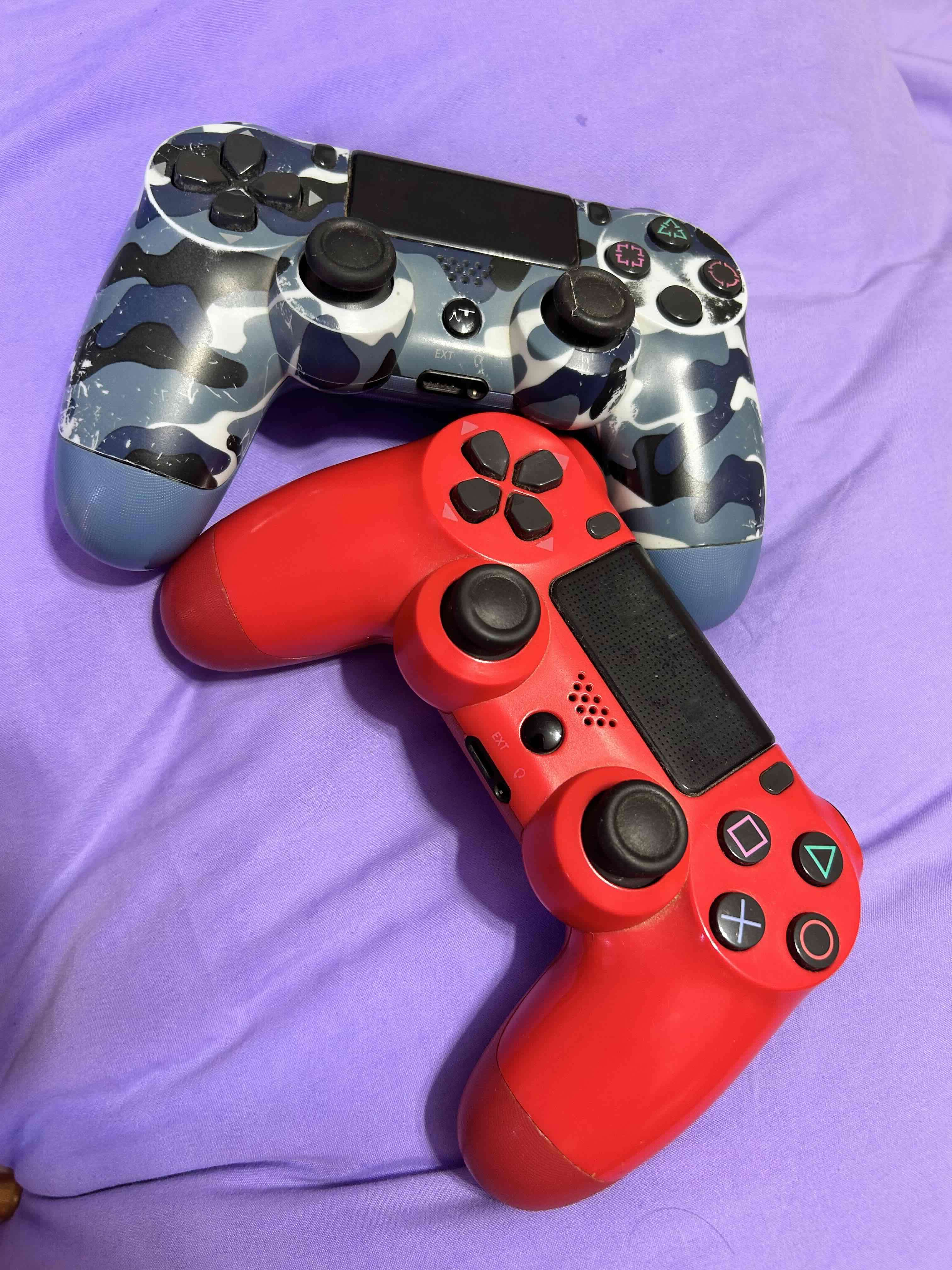 Dos controles PS4 rojo y camuflado