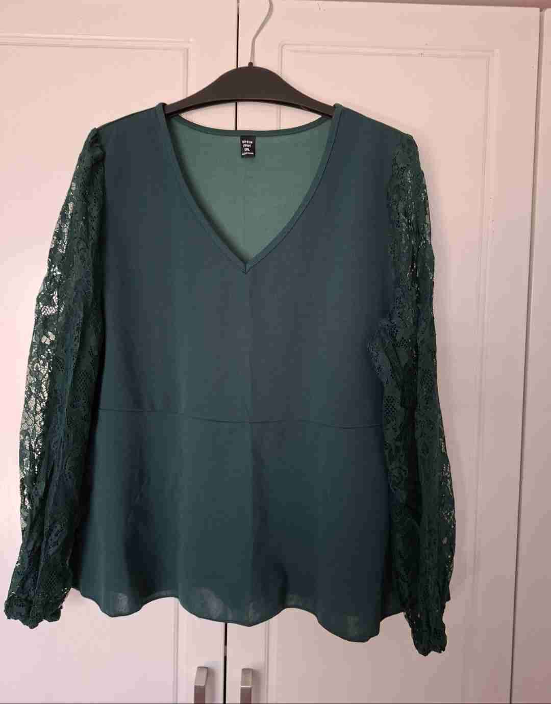 Blusa verde corte peplum con mangas de encaje