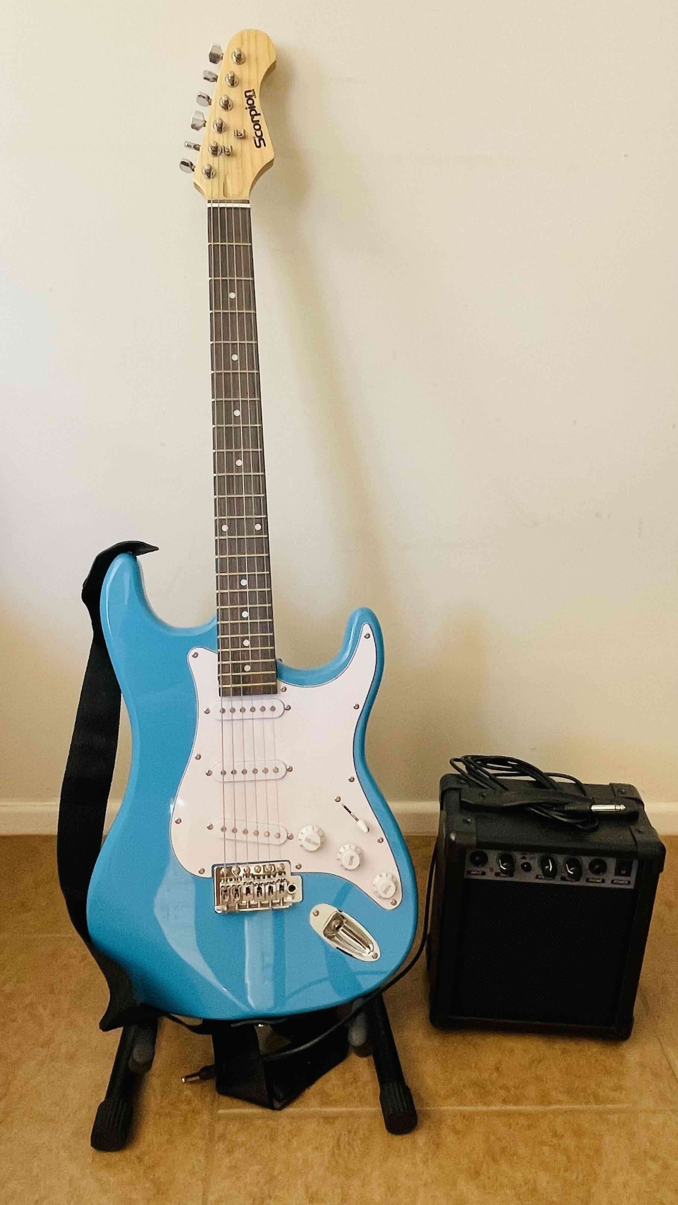 Guitarra eléctrica azul con amplificador