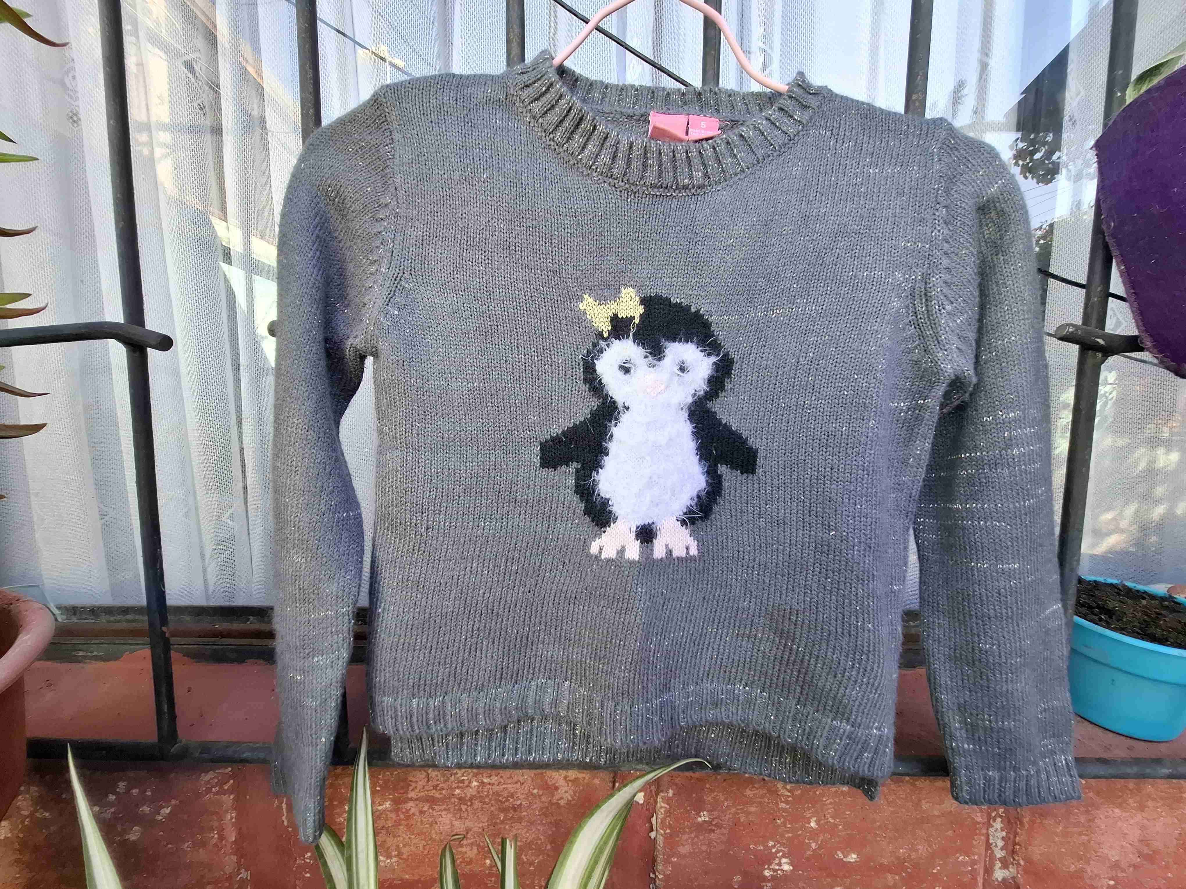 Suéter gris con pingüino