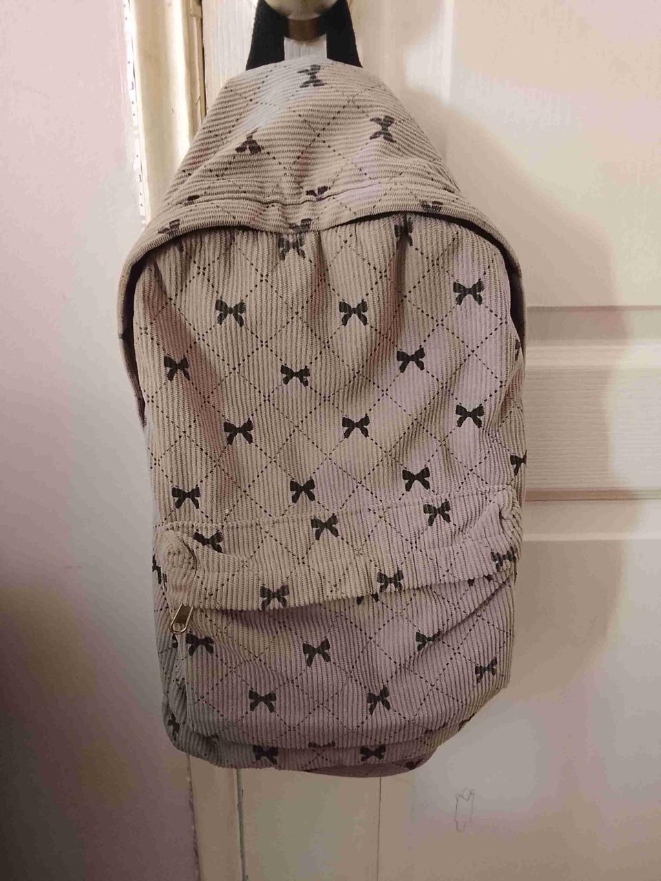 Mochila beige con diseño de moños