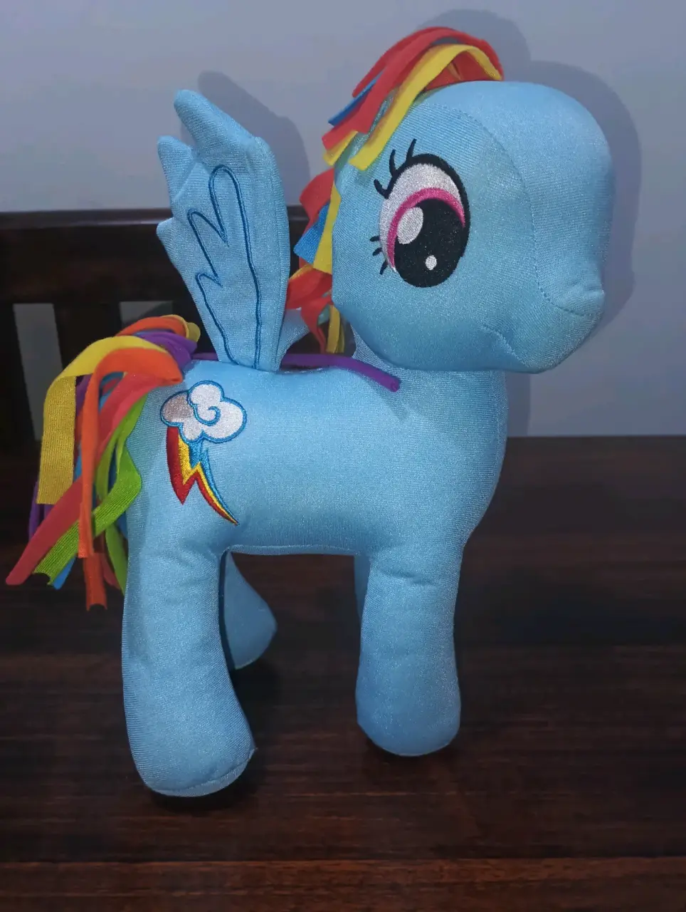 Peluche azul con alas y arcoíris