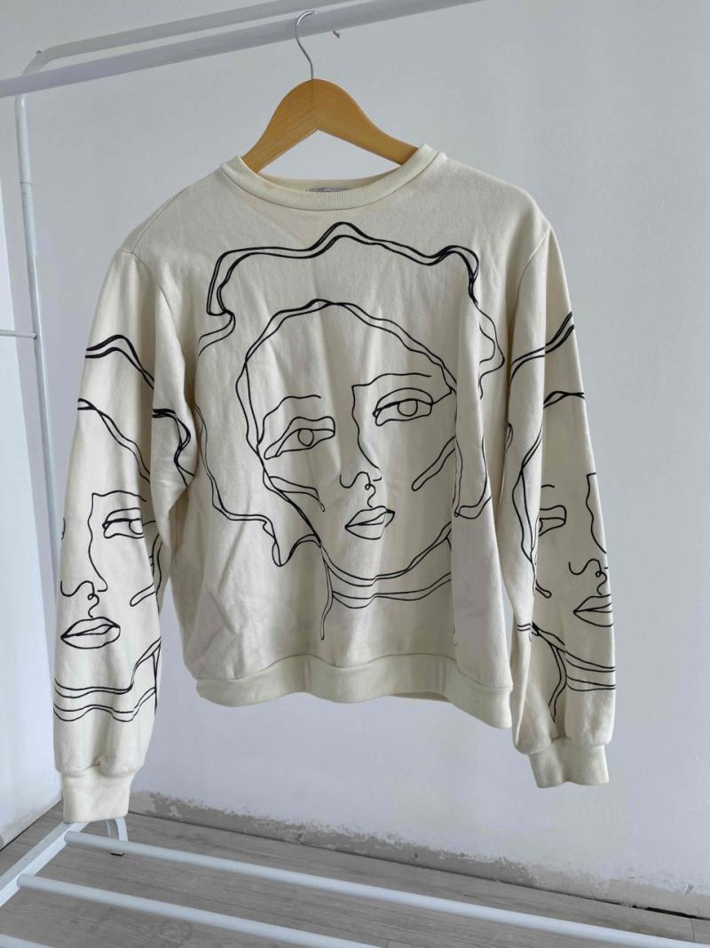 Polerón beige con diseño de rostros - 1