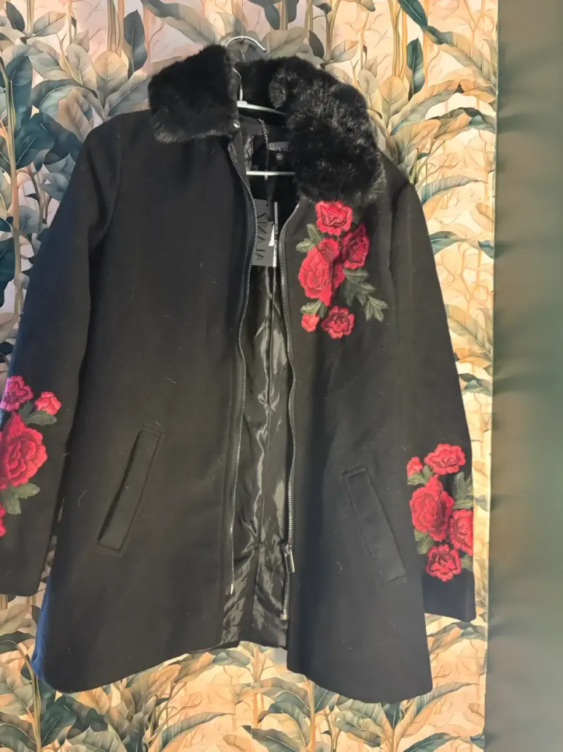 Abrigo negro con rosas bordadas