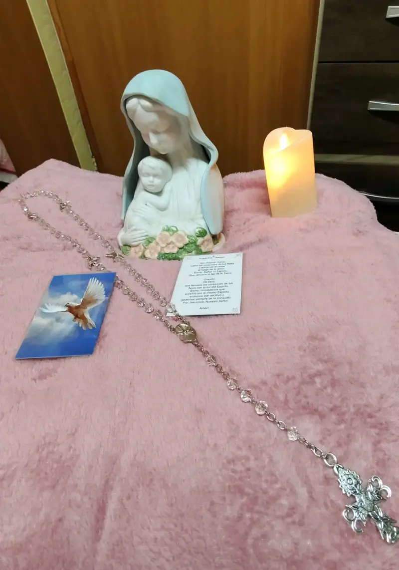 Figura religiosa con rosario