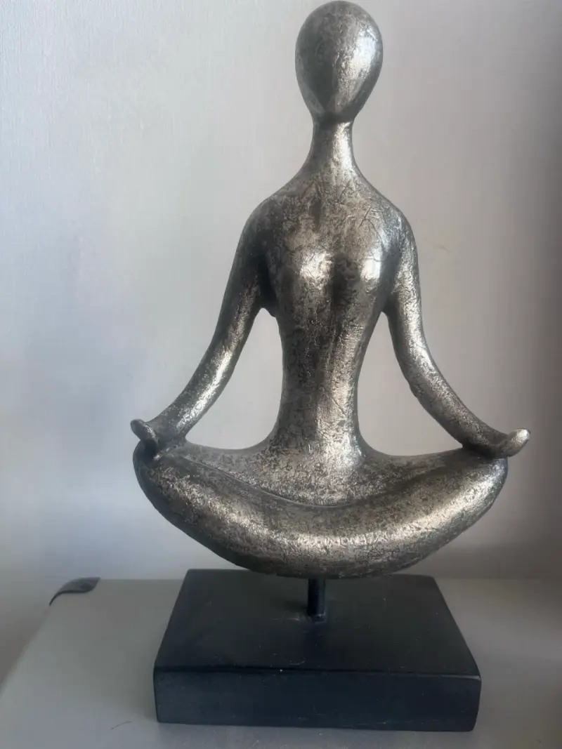 Escultura decorativa en posición de meditación