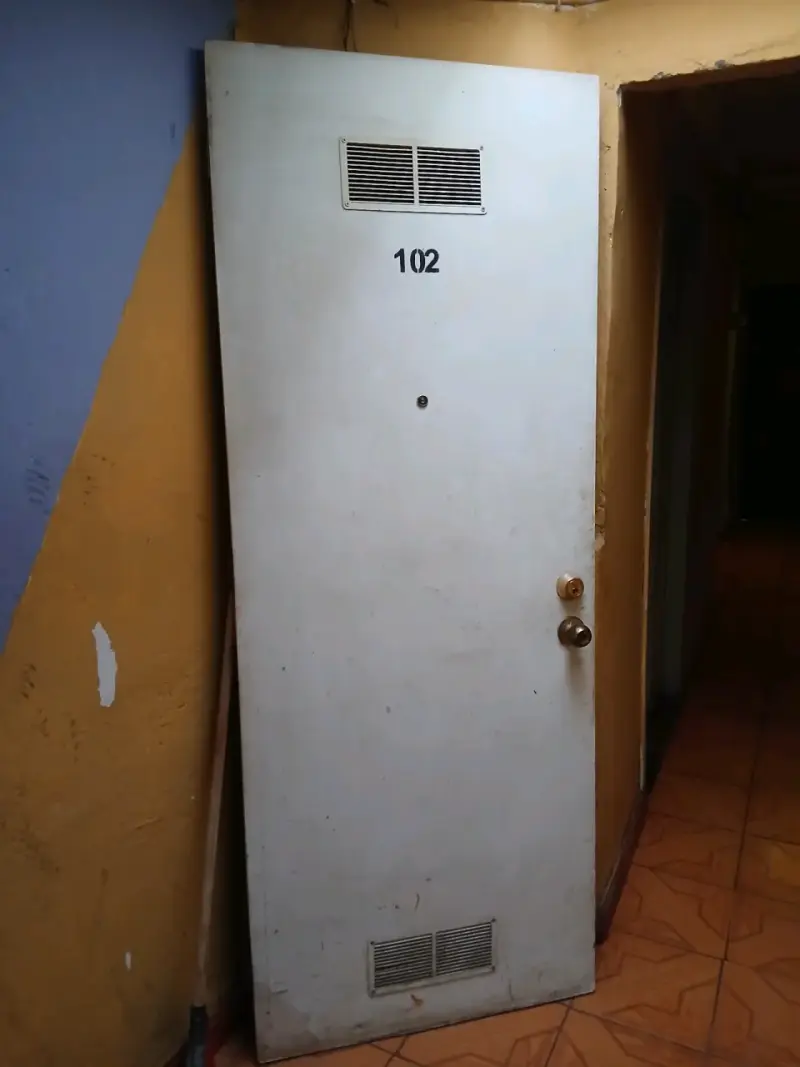 Puerta madera blanca con rejilla