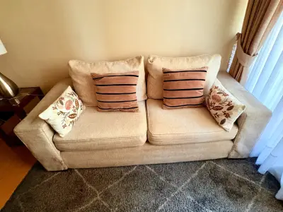 Sofá beige con cojines decorativos - miniatura 1