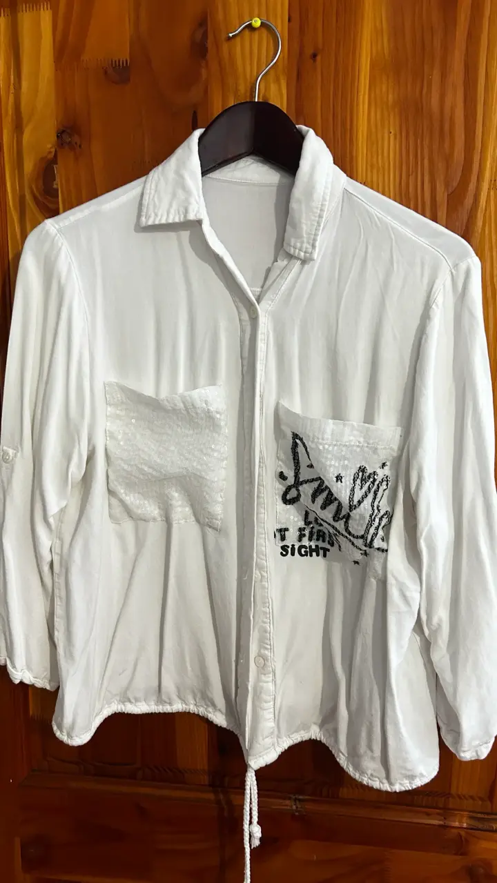 Blusa blanca con bolsillos decorativos