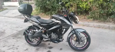 Motocicleta negra con baúl trasero - miniatura 1