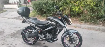 Motocicleta negra con baúl trasero - miniatura 2