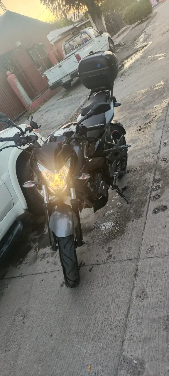 Motocicleta negra con baúl trasero - 3