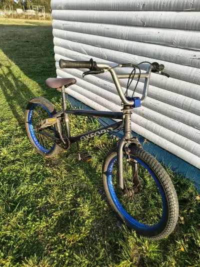 Bicicleta BMX negra con llantas azules - miniatura 2