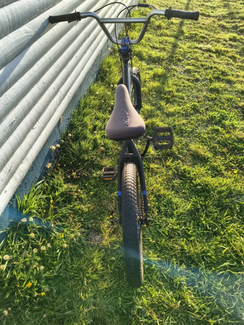 Bicicleta BMX negra con llantas azules - 4