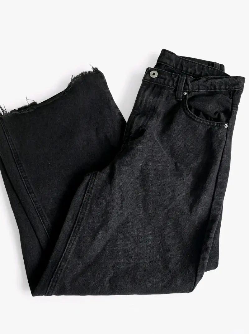 Jeans negros con dobladillo deshilachado