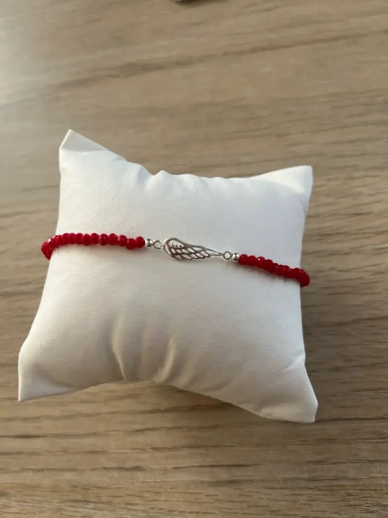 Pulsera roja con ala decorativa