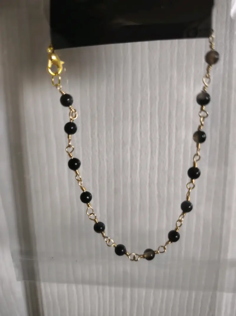 Cadena dorada con cuentas negras