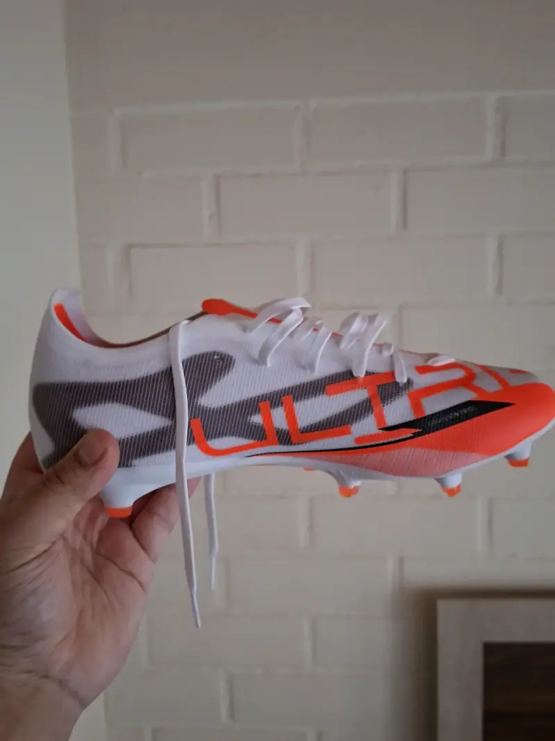Zapatos de fútbol blancos y naranjas