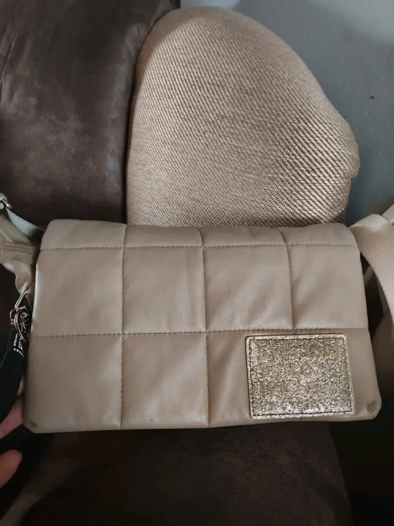 Cartera beige acolchada con detalle dorado