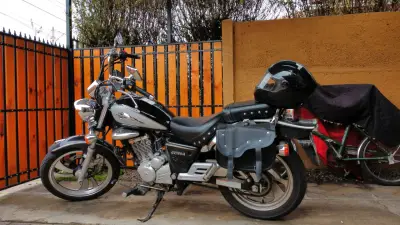 Motocicleta negra con alforjas - miniatura 1