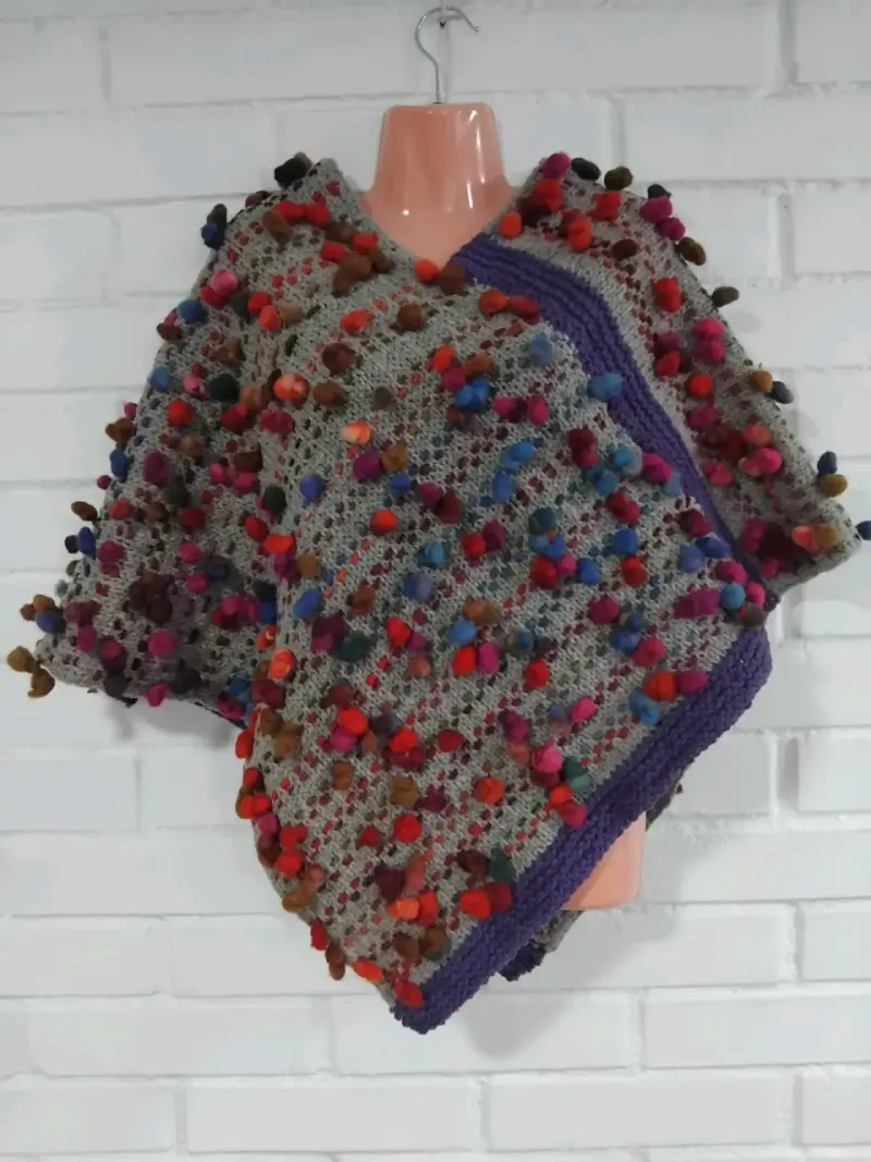 Poncho tejida a mano con pompones