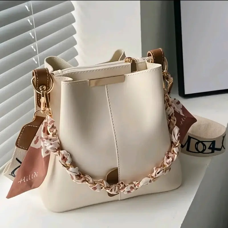 Cartera beige con cadena decorativa